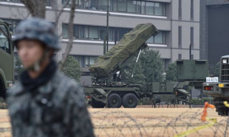 A Japan Self-Defense Forces soldier stands guard near a PAC-3 surface-to-air missile launcher unit (center) in position at the Defense Ministry in Tokyo on March 6, 2017. File Photo: AFP