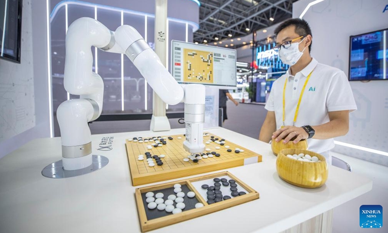 A staff member plays the Chinese board game Go (Weiqi) with a robot at the venue of the 2022 Smart China Expo in southwest China's Chongqing, Aug. 21, 2022.Photo:Xinhua