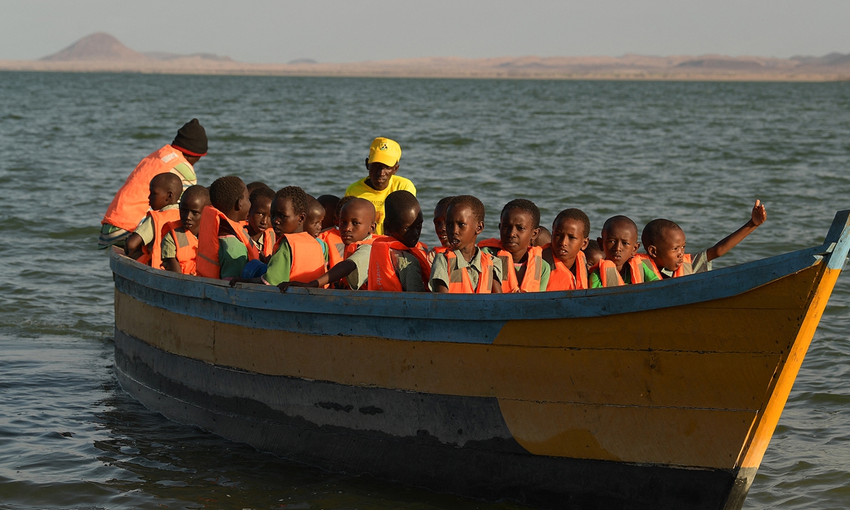 Pupils of El Molo Bay Primary School take a boat to go to school after the road was submerged by rising water from Lake Turkana, near Loiyangalani, northern Kenya, on July 13, 2022. Photo: AFP 