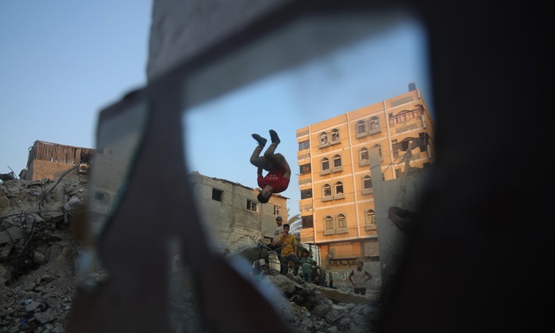 Young people practice parkour over the rubbles of the destroyed houses in the southern Gaza Strip city of Rafah, on Aug. 20, 2022.Photo:Xinhua