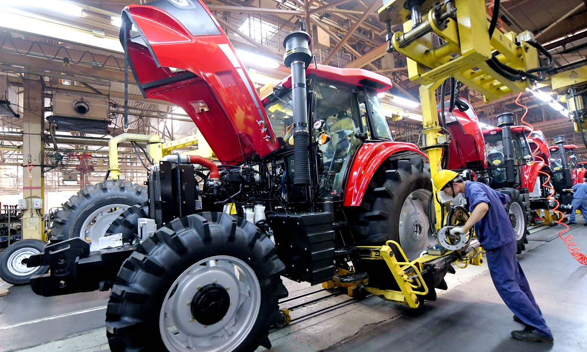 Workers assemble a tractor at a plant in Luoyang, Central China's Henan Province on August 22, 2022. China is pushing tractor upgrading featuring low-emission models. In 2021, the country produced 412,000 large and medium-sized tractors, up 19.4 percent year-on-year. Photo: VCG