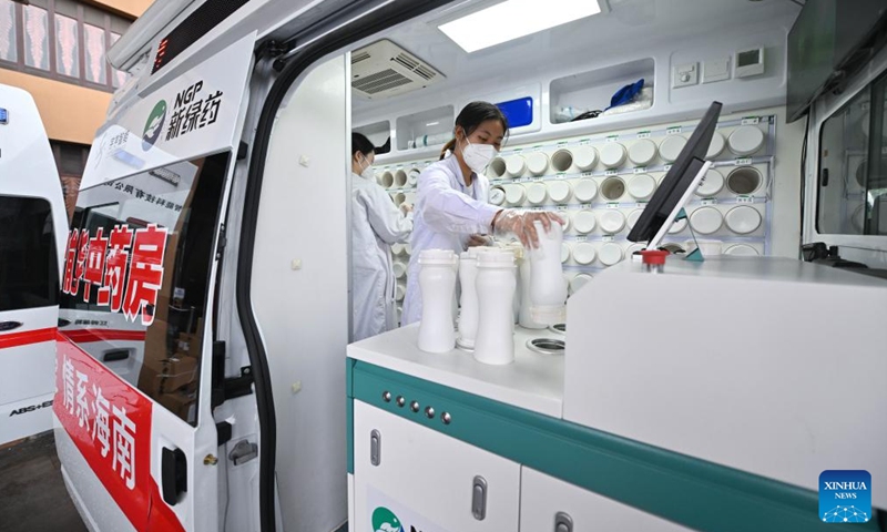 A pharmacist puts a bottle containing concentrated herbal granules into a machine to dispense traditional Chinese medicine (TCM) at a mobile TCM pharmacy in Sanya, south China's Hainan province, Aug. 20, 2022.Photo:Xinhua