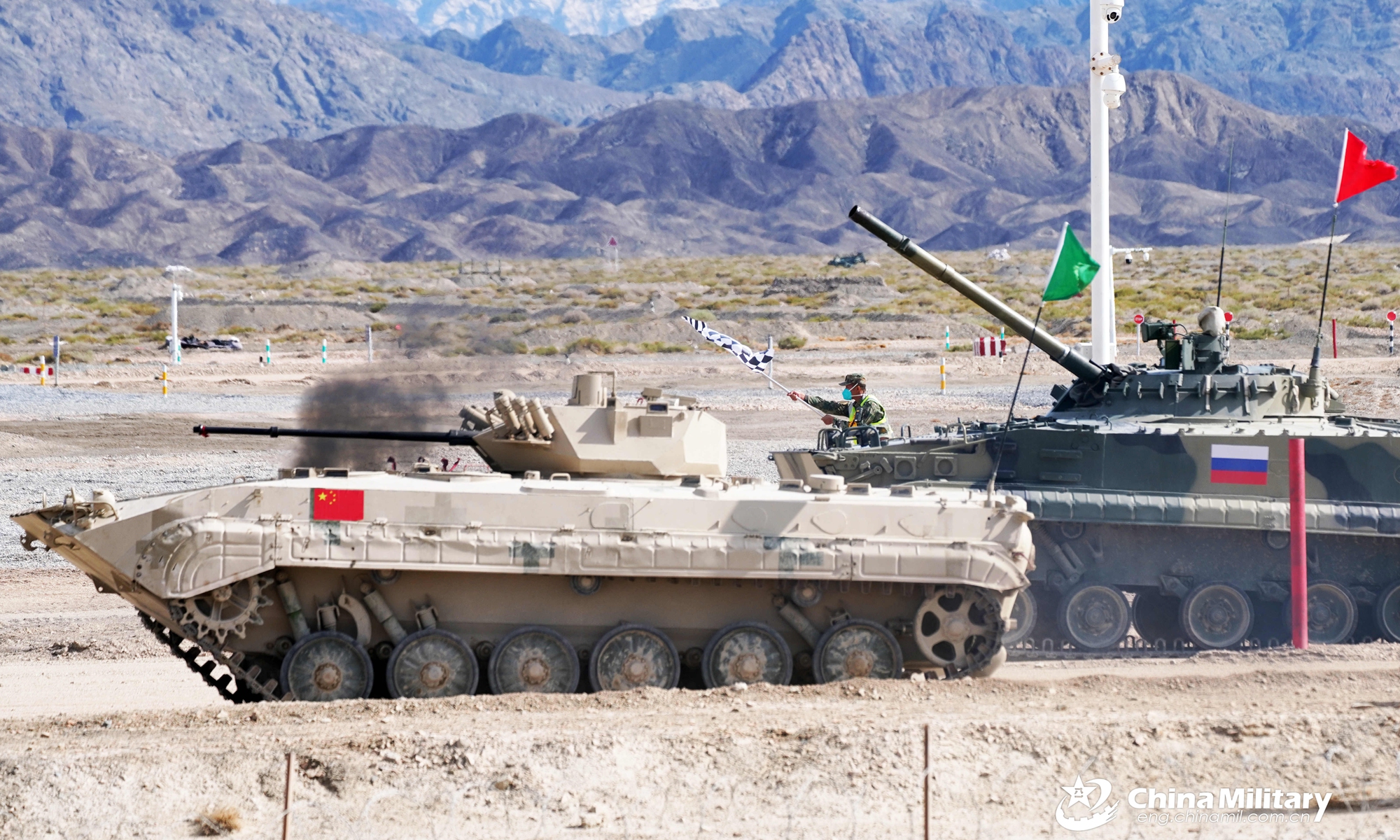 Infantry fighting vehicles of the Chinese team and the Russian team pull out into the track from the starting line in the relay race, the last stage of Suvorov Onslaught contest of the International Army Games 2022 (IAG 2022) in Korla, China's Xinjiang Uygur Autonomous Region, on August 21, 2022.Photo:eng.chinamil.com.cn