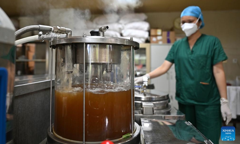 A pharmacist makes traditional Chinese medicine (TCM) decoction at the Traditional Chinese Medicine Hospital of Sanya City in Sanya, south China's Hainan province, Aug. 20, 2022.Photo:Xinhua