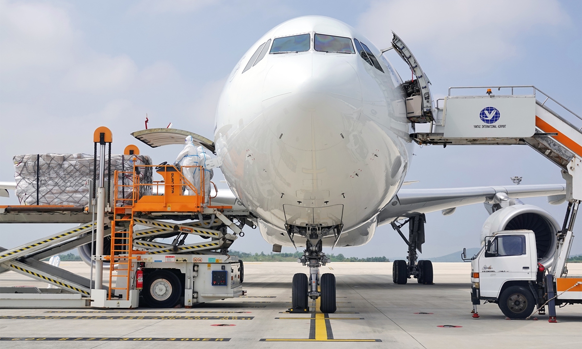 Workers load cargo on a plane at Yantai Penglai International Airport in East China's Shandong Province, on September 1, 2022, as the international air cargo route between Yantai and Liege in Belgium begins operations. This route is operated three times a week by two cargo planes owned by China Eastern Airlines. Photo: VCG