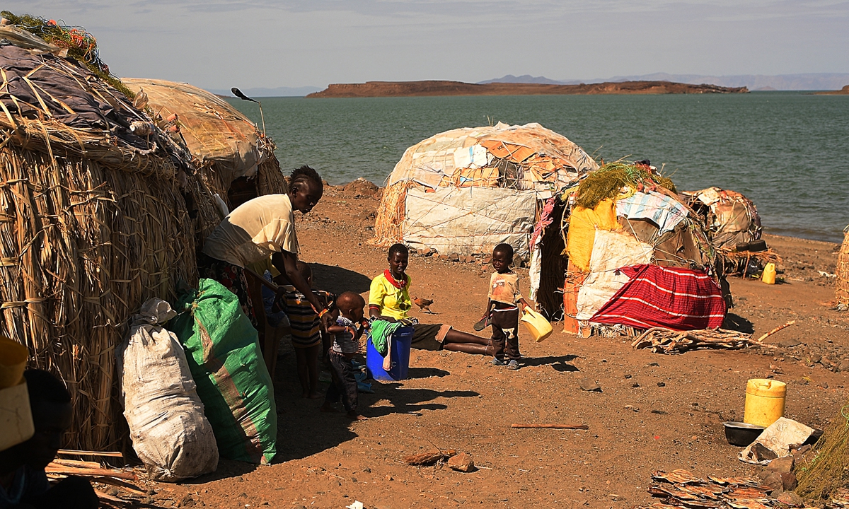 A family from the El Molo community sit outside their new makeshift house after being forced to relocate following rising waters from Lake Turkana, on July 13, 2022. Photo: AFP 