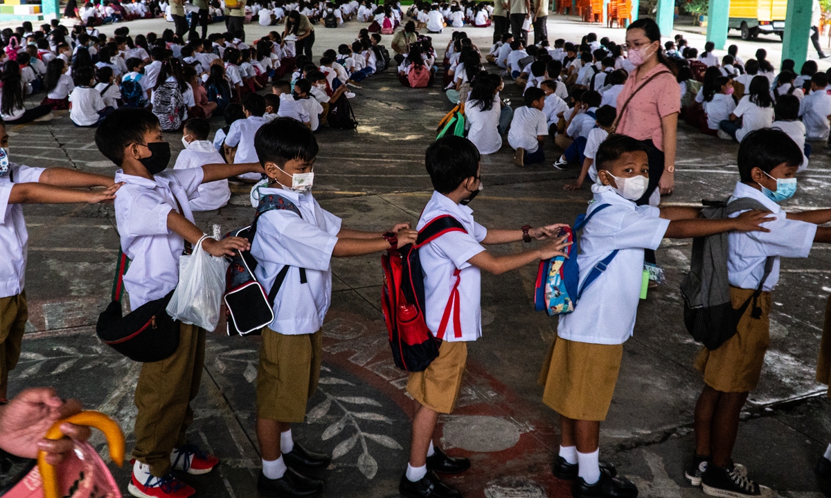 Filipino students wait in line to enter their classrooms in a schoolyard after face-to-face education returned to public schools in Manila, the Philippines on August 22, 2022. Photo: VCG