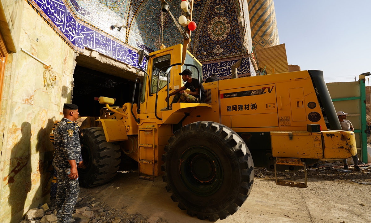 Emergency services and rescue workers try to remove the rubble and debris at the Qattarat al-Imam Ali shrine near Karbala, Iraq, on August 21, 2022. The bodies of two pilgrims were pulled from the shrine on August 22, two days after its partial collapse in a landslide, taking the overall toll to seven deaths, rescuers said. Photo: VCG
