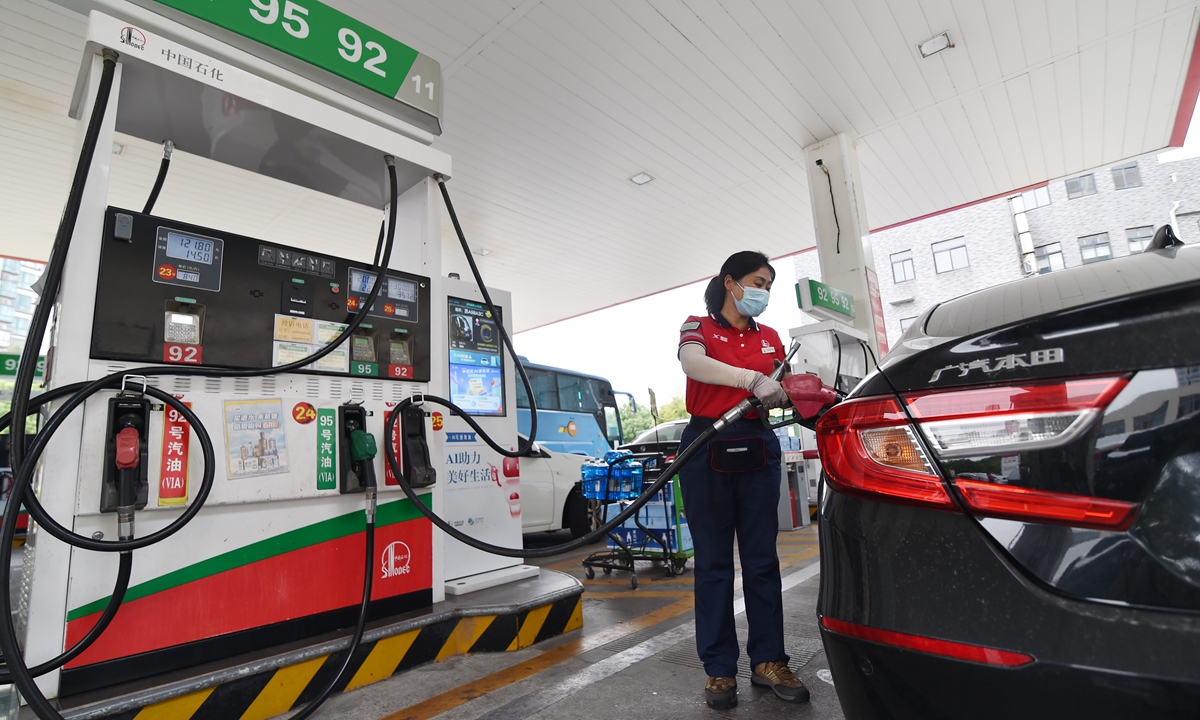 A worker fills up a car at a gas station in East China's Jiangsu Province on August 23, 2022. China will cut the retail prices of gasoline and diesel by 205 yuan ($29.92) and 200 yuan per ton, respectively, on August 24, according to the National Development and Reform Commission. Photo: VCG