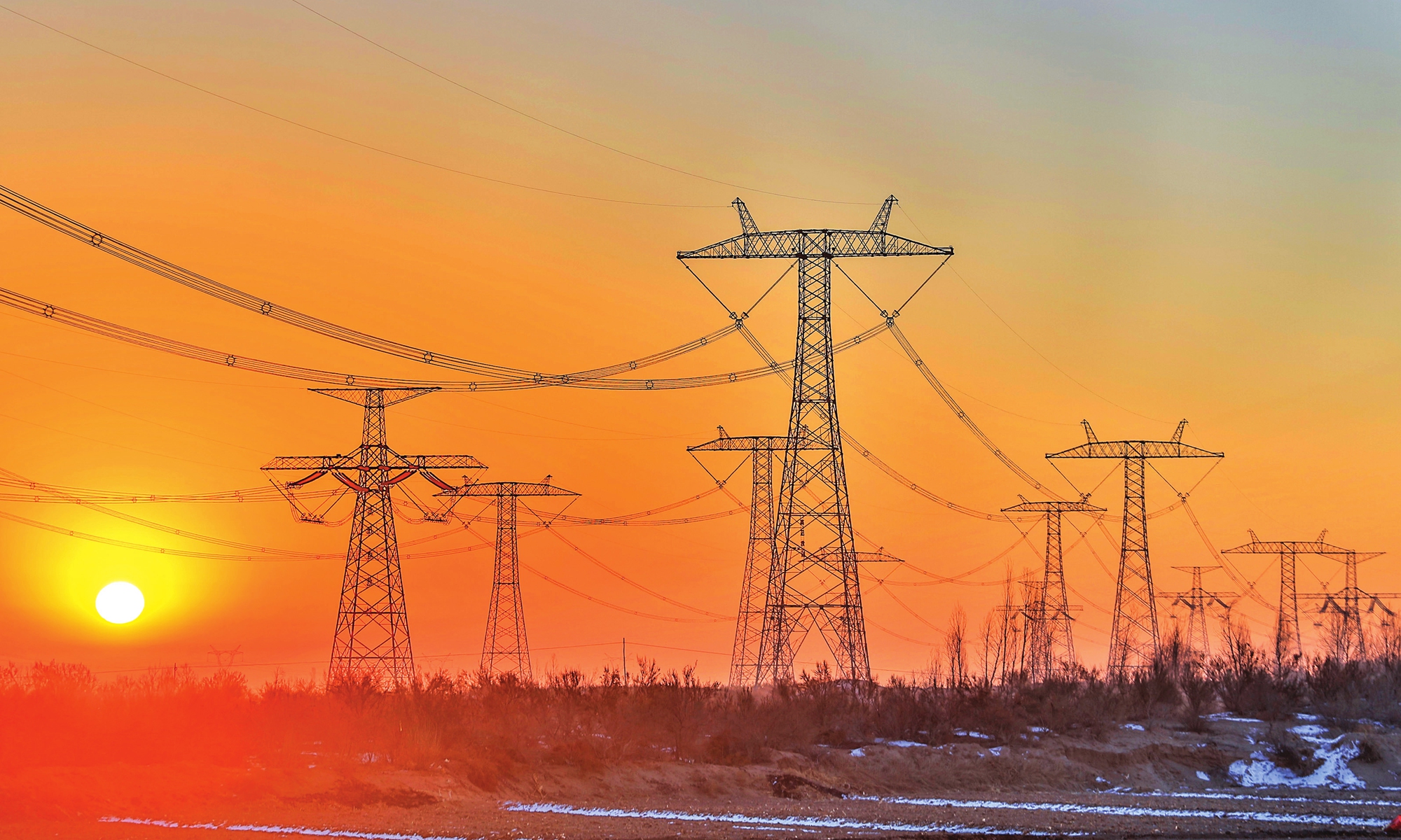 Sunrise over the ultra-high voltage lines of the west-to-east electricity transmission project in Wuwei, Gansu Province, on January 1, 2022 Photo: IC