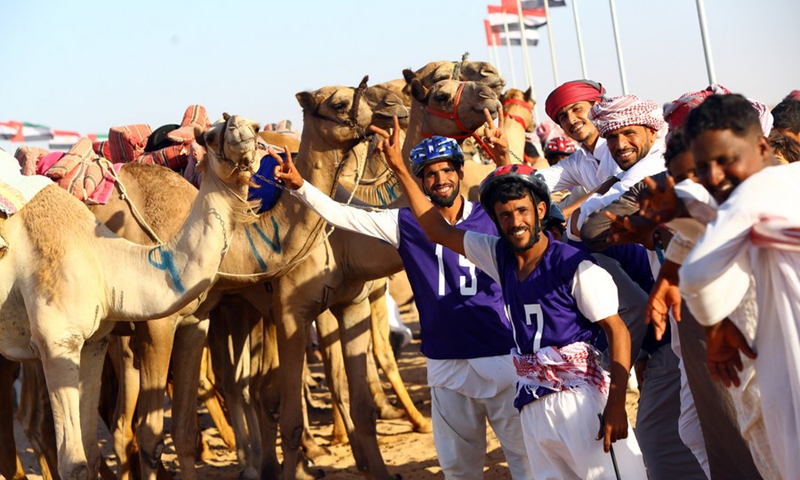 Participants take photos with camels in a camel race in El Alamein City, Egypt, on Aug. 23, 2022.(Photo: Xinhua)