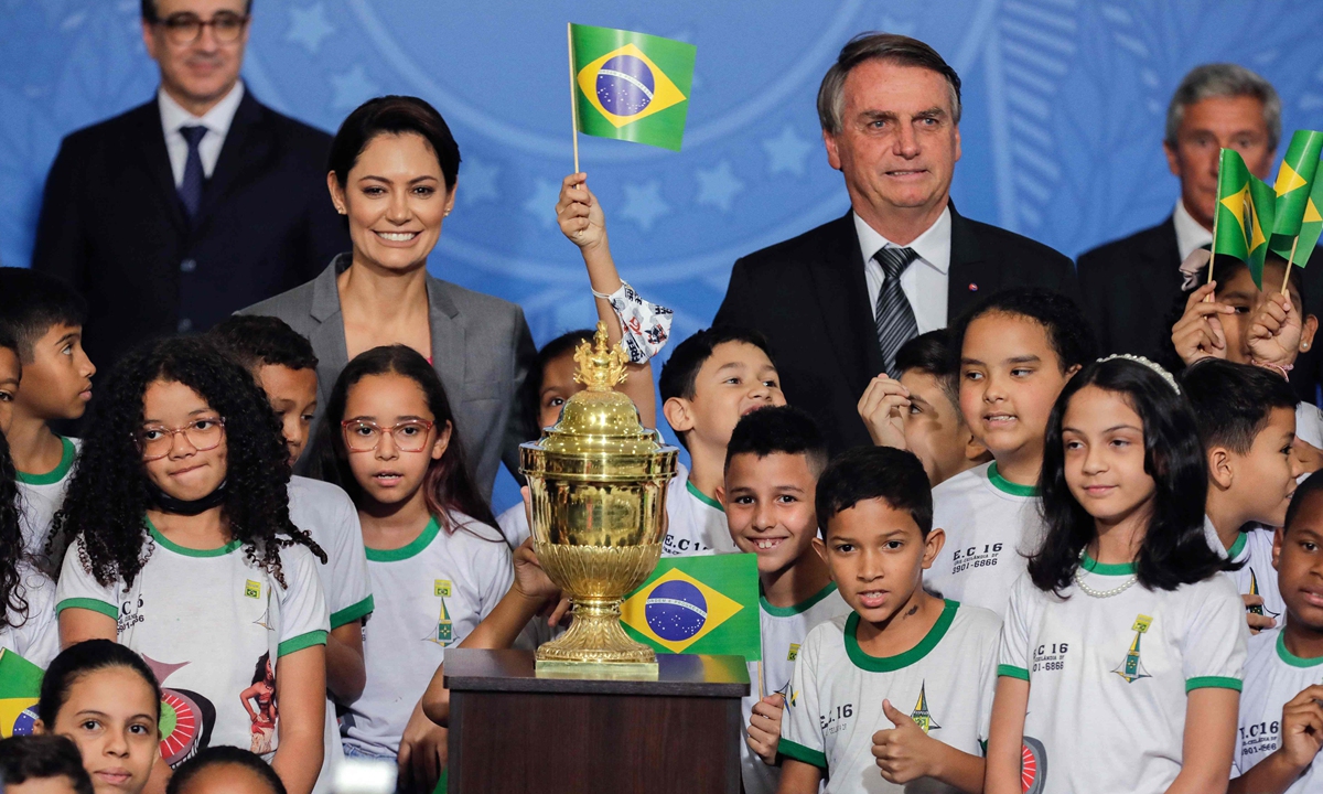 Brazilian President Jair Bolsonaro and First Lady Michelle Bolsonaro are surrounded by children as they stand next to an urn containing the embalmed heart of Dom Pedro I, founder and first ruler of the Empire of Brazil, during an official ceremony with military honors at Planalto Palace in Brasilia, on August 23, 2022. Photo: VCG