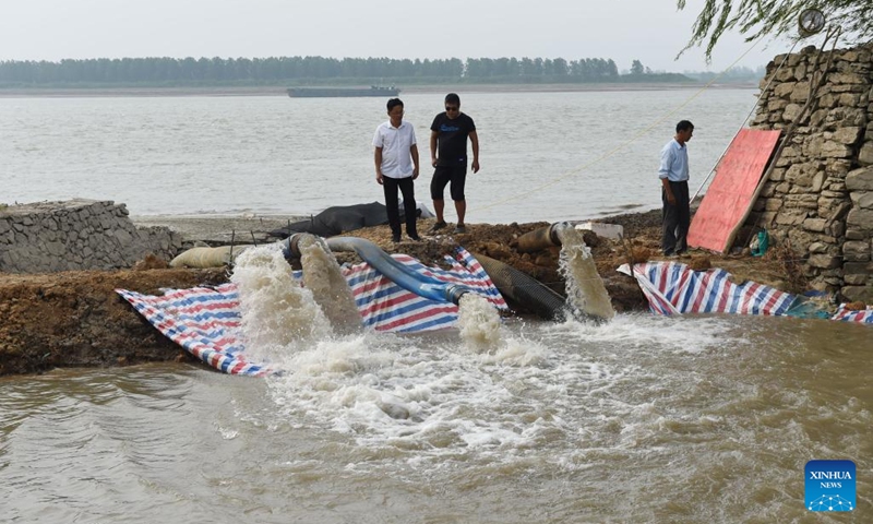 Workers pump water from the Yangtze River for irrigation in Xingang Town, Fanchang District of Wuhu City, east China's Anhui Province, Aug. 23, 2022. High temperatures and the lack of rain in the Yangtze River basin has led to drought in some parts of Fanchang District. Locals channelled water from the Yangtze River into the farmland in various ways to minimize the impact of the drought on agricultural production.(Photo: Xinhua)