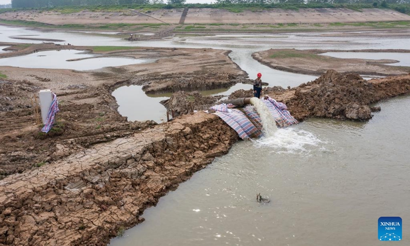 Aerial photo taken on Aug. 23, 2022 shows a worker pumping river water into the water diversion channel for irrigation in Suncun Town, Fanchang District of Wuhu City, east China's Anhui Province. High temperatures and the lack of rain in the Yangtze River basin has led to drought in some parts of Fanchang District. Locals channelled water from the Yangtze River into the farmland in various ways to minimize the impact of the drought on agricultural production.(Photo: Xinhua)