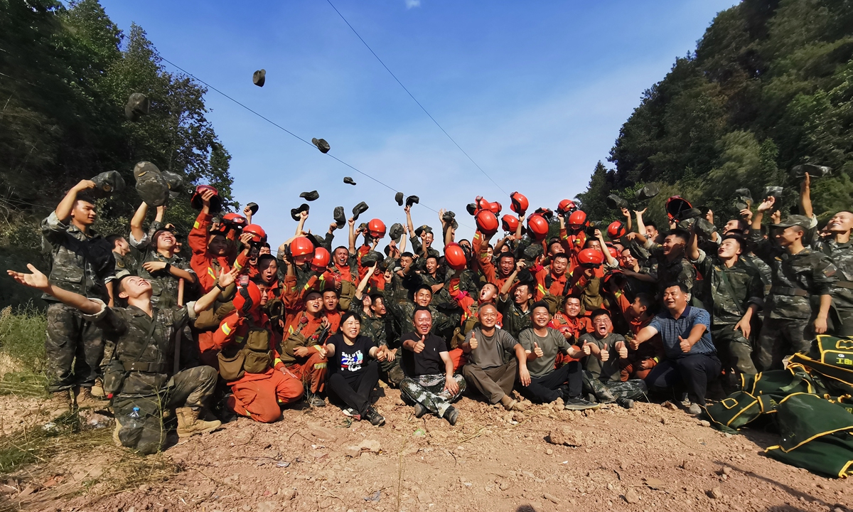 Firefighters and rescue workers celebrate after a forest fire in Dazu district of Southwest China's Chongqing Municipality was put out on August 25, 2022, following five days and four nights of arduous work. Photo: IC