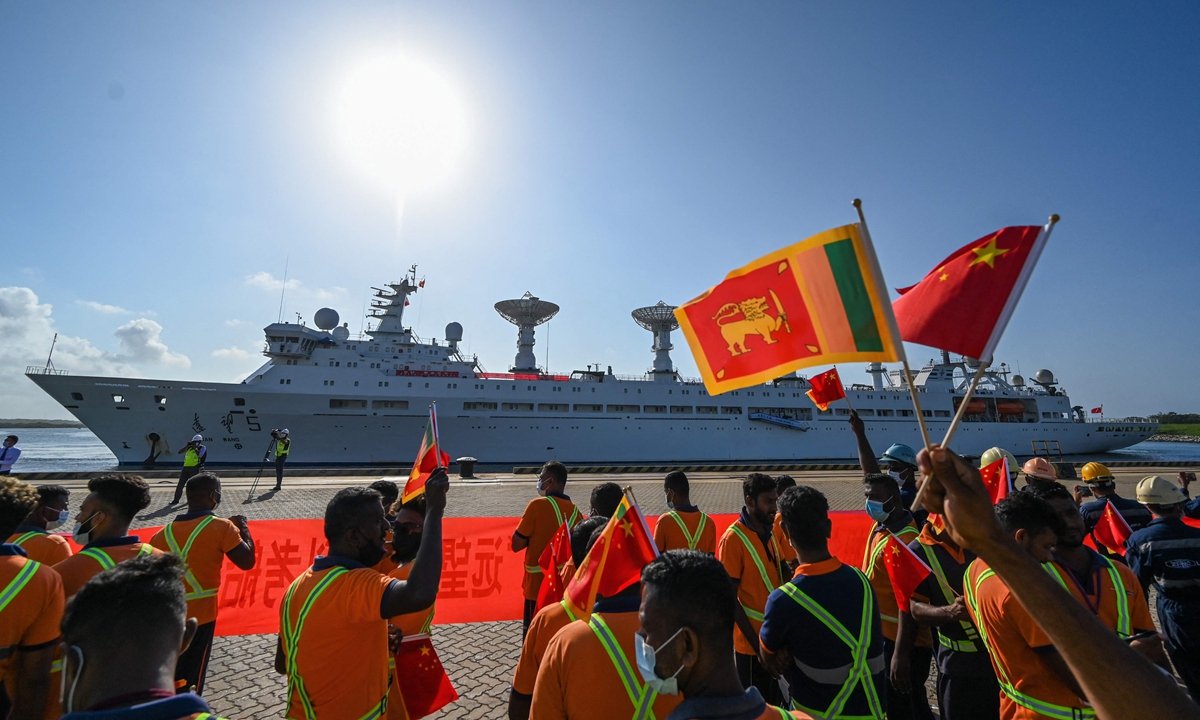 Workers wave the Chinese and Sri Lankan national flags upon the arrival of China's research and survey vessel, the Yuanwang-5 at Hambantota port, Sri Lanka on August 16, 2022. Photo: VCG