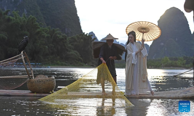 A visitor poses for photos at Xingping Town in Yangshuo County of Guilin, south China's Guangxi Zhuang Autonomous Region, Aug. 25, 2022.Photo:Xinhua