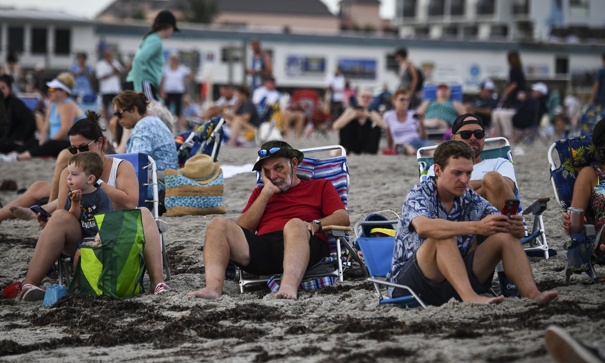 Beachgoers wait for the launch of the Artemis I unmanned lunar rocket, in Florida. Photos: AFP