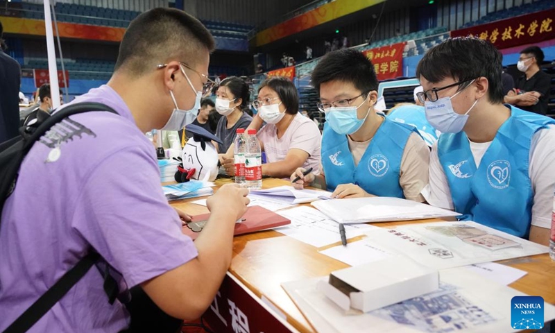 A freshman (1st L) registers at Peking University in Beijing, capital of China, on Aug. 28, 2022.Photo:Xinhua