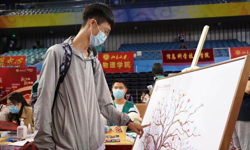 A freshman makes a fingerprint onto a painting while registering at Peking University in Beijing, capital of China, on Aug. 28, 2022.Photo:Xinhua