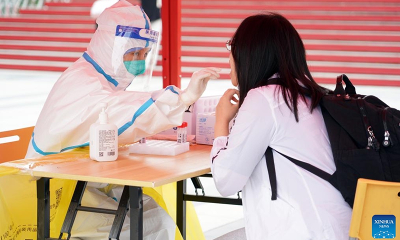 A medical worker takes a swab sample from a freshman for nucleic acid test at Peking University in Beijing, capital of China, on Aug. 28, 2022.Photo:Xinhua