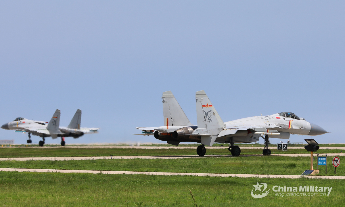Two carrier-based fighter jets attached to a naval aviation unit taxi on the runway before takeoff for a flight training exercise on July 29, 2022. Photo:China Military