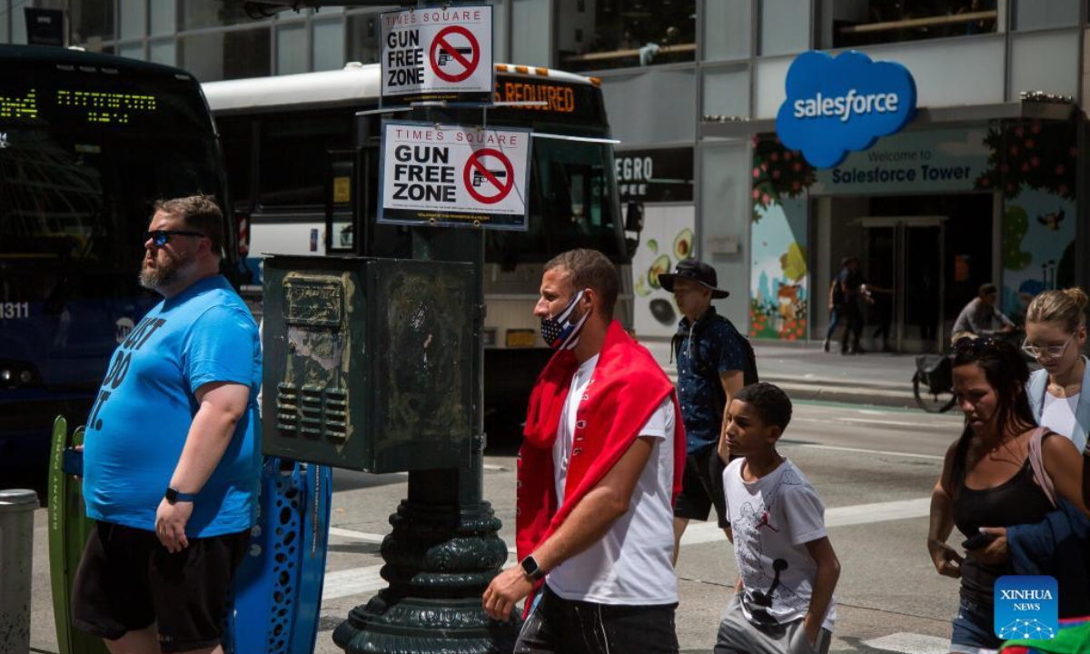 Passersby walk past a gun-free zone signboard near Times Square in New York, the United States, Sep 1, 2022. Photo:Xinhua