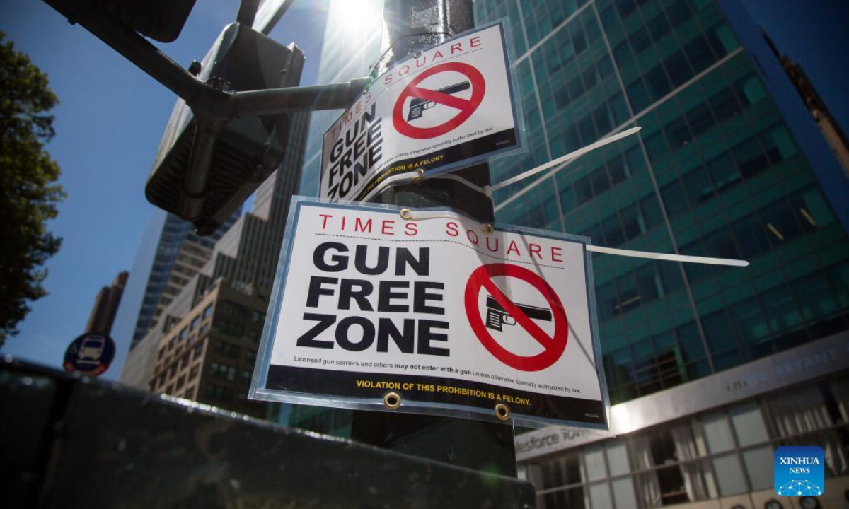 Passersby walk past a gun-free zone signboard near Times Square in New York, the United States, Sep 1, 2022. Photo:Xinhua