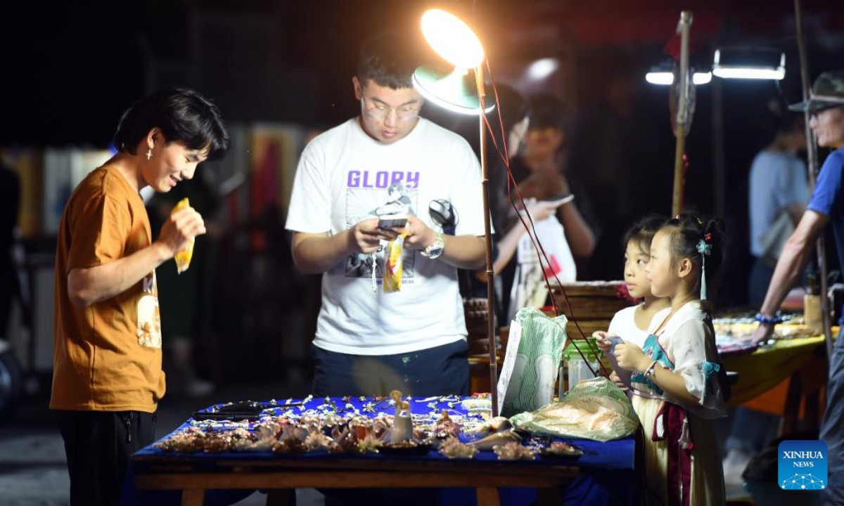 Tourists visit a vendor's stand in Hongcun Village in Yixian County, east China's Anhui Province, Aug. 31, 2022. Hongcun Village deeply integrates night economy with tourism industry to promote rural development. Photo:Xinhua