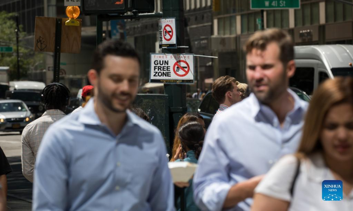 Passersby walk past a gun-free zone signboard near Times Square in New York, the United States, Sep 1, 2022. Photo:Xinhua