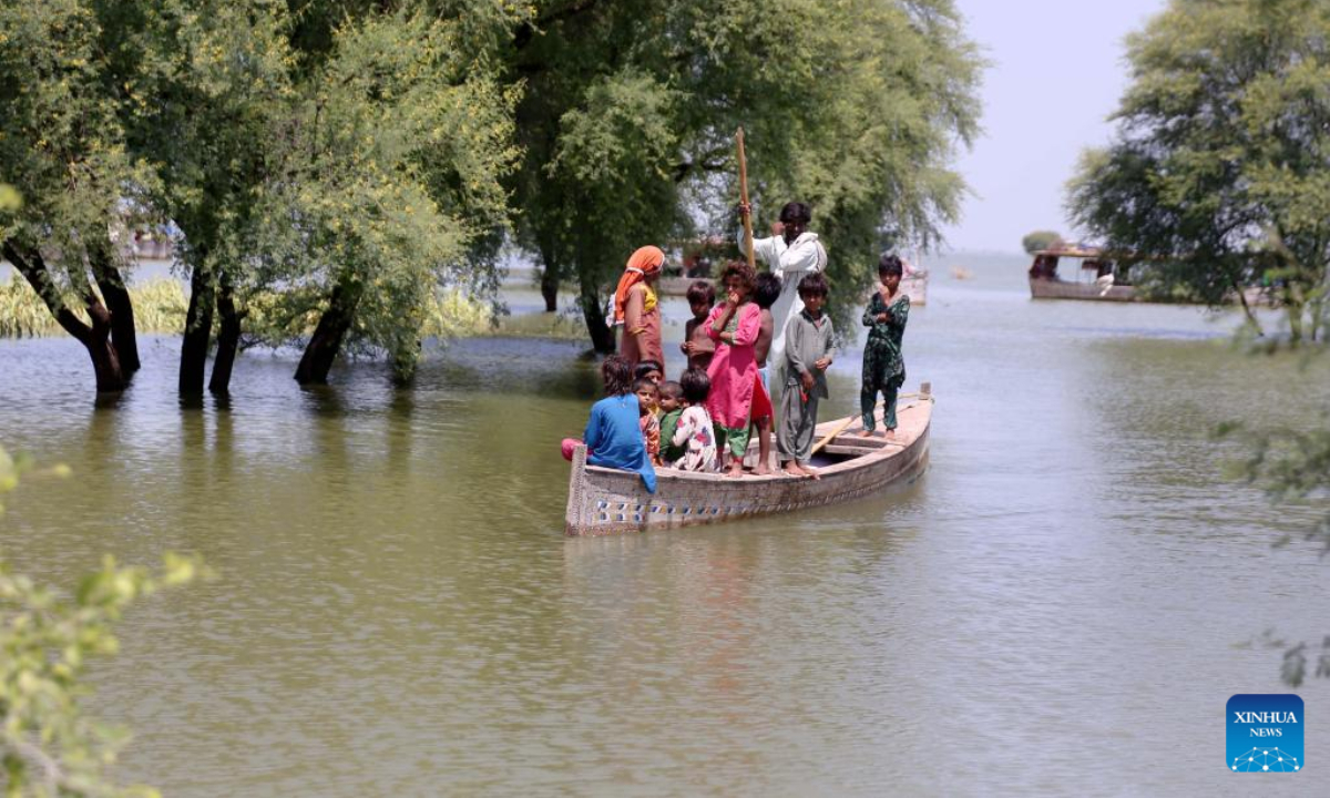 Flood-affected people travel on a boat in flood-hit Dadu district in Pakistan's Sindh province on Aug 31, 2022. Photo:Xinhua