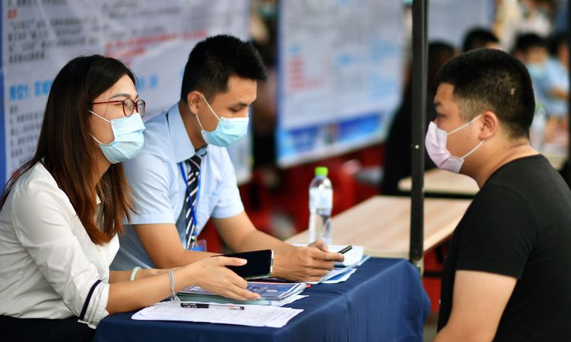 An employer (L) communicates with a job seeker at a job fair in Haikou, south China's Hainan Province. File Photo: Xinhua