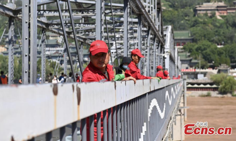 Workers clean the century-old Zhongshan bridge over the Yellow River in Lanzhou, northwest China's Ganxu Province, Sept. 6, 2022. (Photo: China News Service/Li Yalong)