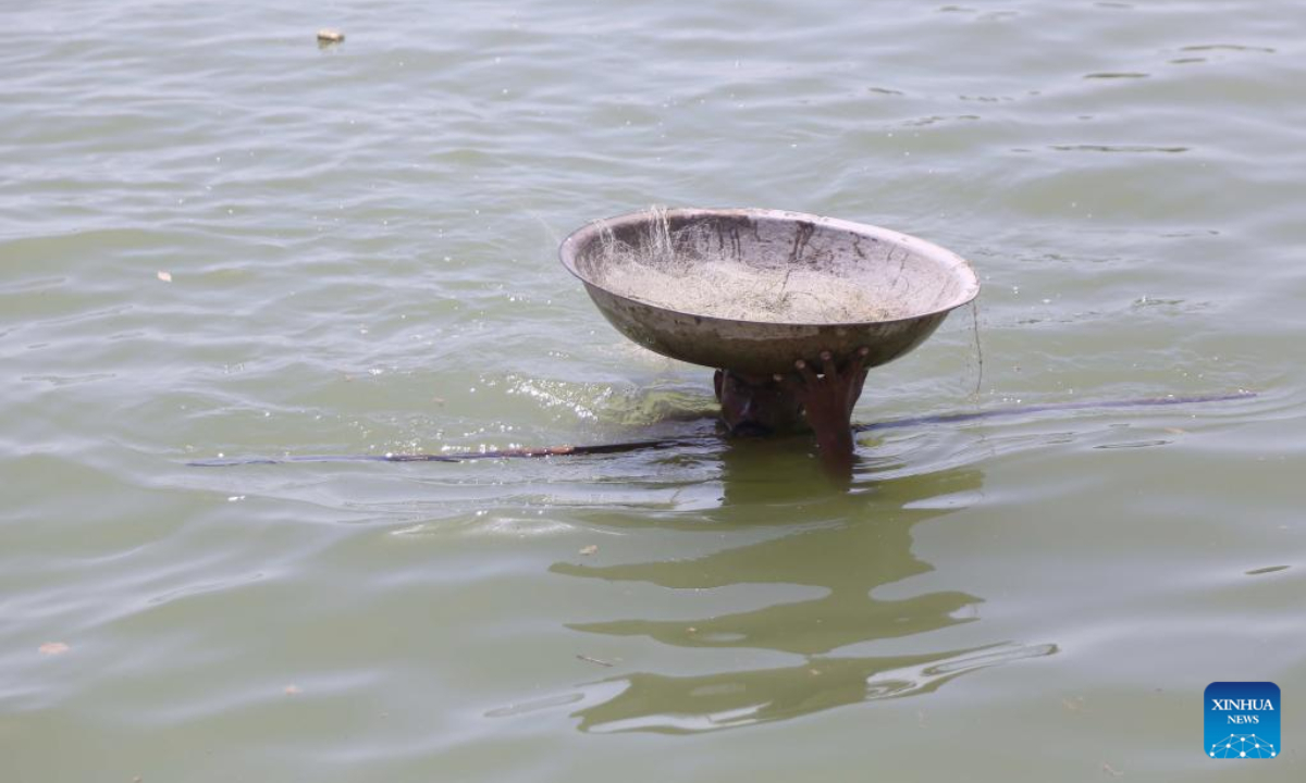 A flood-affected man wades through flood water in flood-hit Dadu district in Pakistan's Sindh province on Aug 31, 2022. Photo:Xinhua