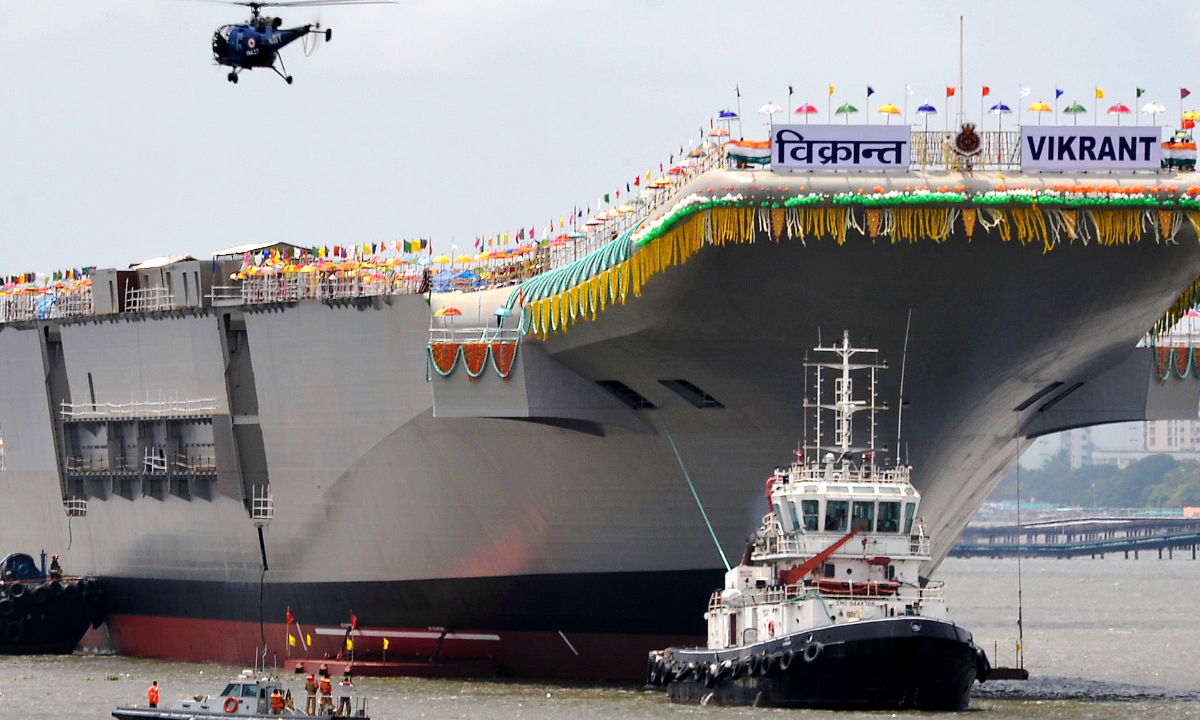 A tugboat guides the indigenously built aircraft carrier INS Vikrant as it leaves the shipyard after the launch ceremony in Kochi. Photo:AFP