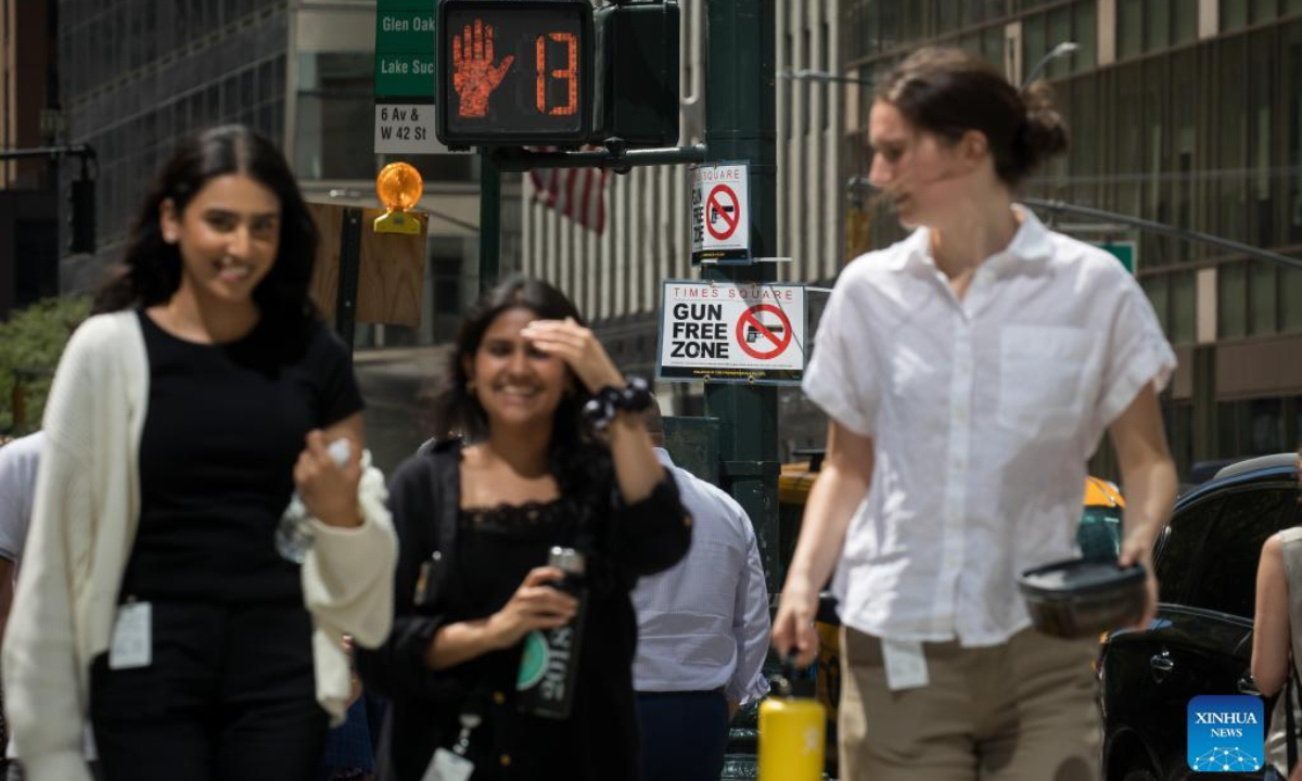 Passersby walk past a gun-free zone signboard near Times Square in New York, the United States, Sep 1, 2022. Photo:Xinhua
