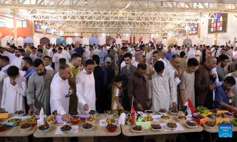 Visitors taste different types of dates displayed at the sixth annual date festival in Dhuluiya, Iraq, on Sept. 9, 2022. (Xinhua/Khalil Dawood)