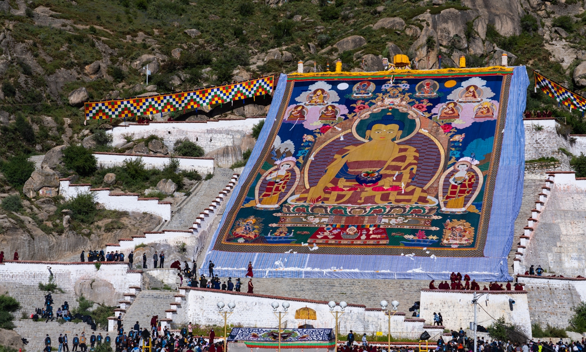 An artist works on a thangka painting. 
Photo: Courtesy of Tashi Choedak  A thangka painting of a giant Buddha on display during the Shoton Festival in Lhasa Photo: VCG