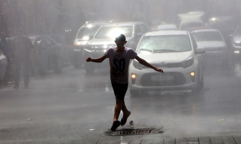 A man cools off in a spray of water from a water truck during a heatwave in Amman, Jordan, on Aug. 28, 2022.(Photo: Xinhua)