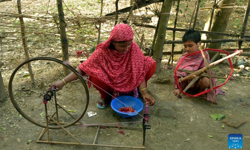 A woman and a girl spin yarn for the Jamdani saree in Narayanganj, Bangladesh, Aug. 24, 2022.(Photo: Xinhua)