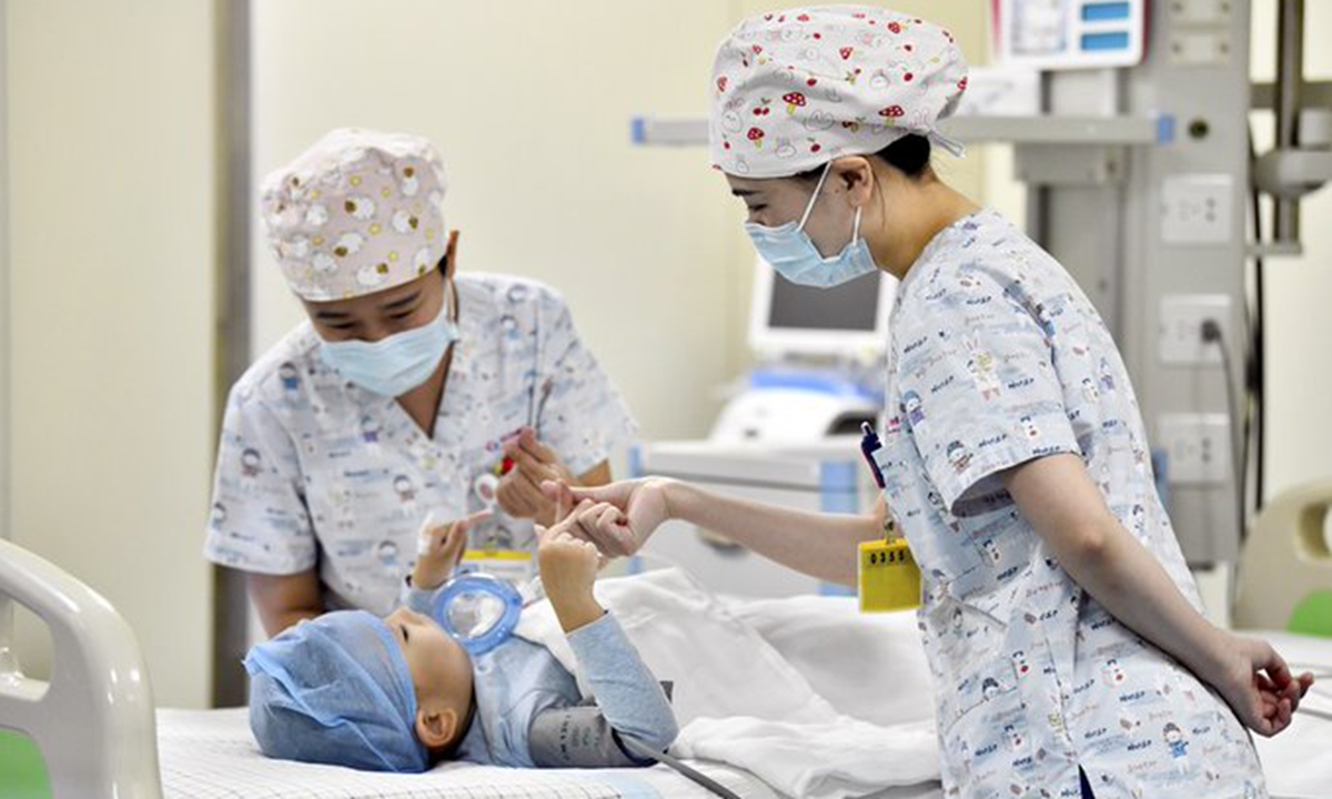 Medical workers encourage a 4-year-old child diagnosed with spinal muscular atrophy after the injection of Spinraza at a hospital in Zaozhuang, east China's Shandong Province, Jan. 1, 2022. China is striving to improve the diagnosis and treatment of rare diseases. (Xinhua) 





