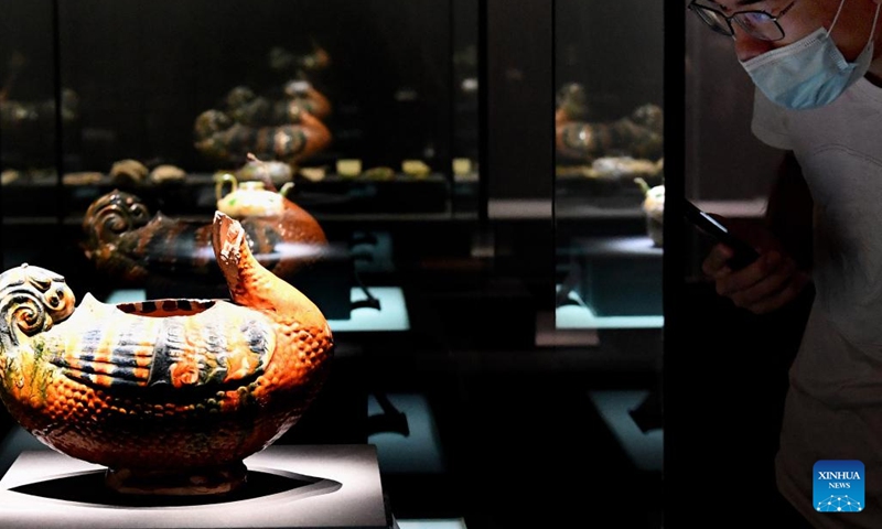 A visitor views an exhibit during a joint exhibition of tri-colored glazed potteries in Zhengzhou, central China's Henan Province, Aug. 30, 2022. The joint exhibition displayed more than 300 tri-colored glazed potteries of the Tang Dynasty (618-907) unearthed from 10 kilns of five provinces in China.(Photo: Xinhua)