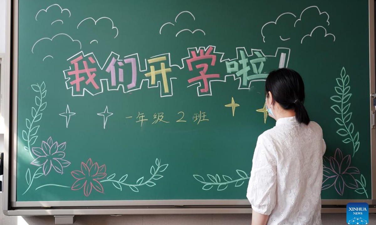 A teacher writes welcoming words on the blackboard in the Experimental Primary School of RDFZ (The High School Affiliated to Renmin University of China) in Haidian District of Beijing, capital of China, Aug. 30, 2022. Schools in Zhongguancun area of Haidian District have organized staff members to make full preparation for the upcoming new semester. (Xinhua/Ren Chao)
