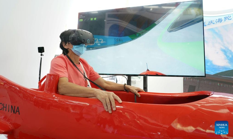A visitor rides a VR-powered bobsleigh at the cultural and tourism services exhibition hall in the Shougang Park during the 2022 China International Fair for Trade in Services (CIFTIS) in Beijing, capital of China, Sept. 5, 2022. (Xinhua/Ren Chao)