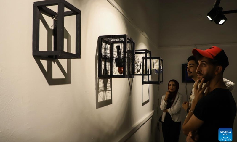 Palestinian people view artworks during an exhibition called No One Yearns for Pain at Shababek for Contemporary Art in Gaza City, on Aug. 31, 2022.(Photo: Xinhua)