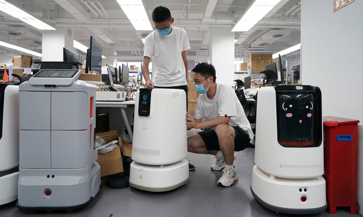 Engineers of a service robot company set up a service robot at Zhongguancun Dongsheng science park in Haidian District of Beijing, capital of China, Aug. 15, 2022. (Xinhua/Ren Chao)


