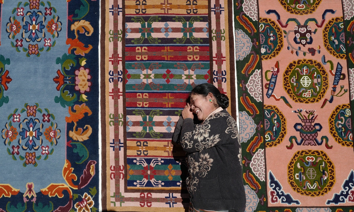 Craftswoman Sonam Pemdo poses for a photo with handmade Tibetan rugs. Photos: Courtesy of Xu Chengcheng An exhibition of handmade Tibetan rugs at Beijing's 798 Art Zone in August 2022 