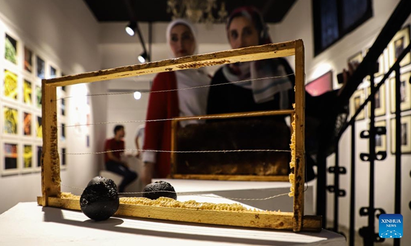 Palestinian people view an artwork during an exhibition called No One Yearns for Pain at Shababek for Contemporary Art in Gaza City, on Aug. 31, 2022.(Photo: Xinhua)