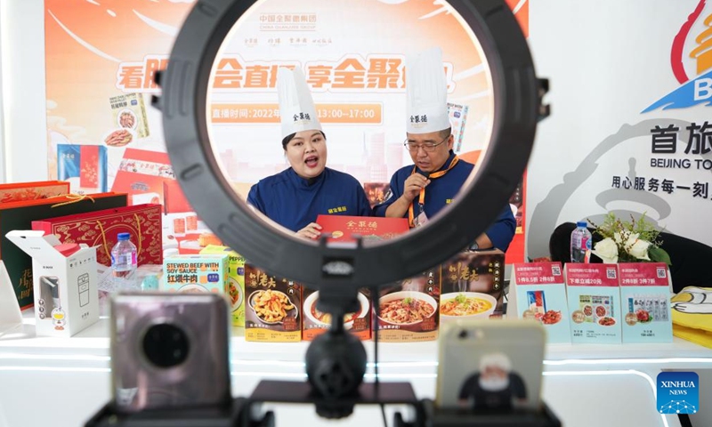 Staff members of Quanjude, one of China's best-known roast duck chain restaurants, sell products via a live show at the cultural and tourism services exhibition hall in the Shougang Park during the 2022 China International Fair for Trade in Services (CIFTIS) in Beijing, capital of China, Sept. 1, 2022. (Xinhua/Ju Huanzong)