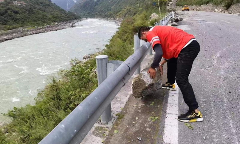 A worker removes a rock from the S217 provincial highway after an earthquake in Luding County of southwest China's Sichuan Province, on Sept. 6, 2022. A 6.8-magnitude earthquake jolted Luding County on Monday. Rescuers have been organized to restore and maintain damaged road access. (Xinhua)